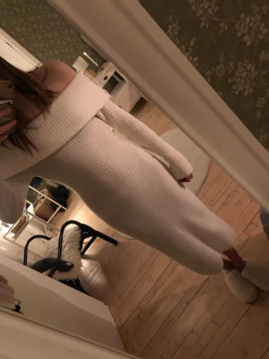 Vit ribbad offshoulder klänning - Säljer en superfin vit ribbad klänning med offshoulder-design och lång ärm. Klänningen är lång och har en tight passform som framhäver figuren. Perfekt för dig som vill ha en stilren och trendig look.