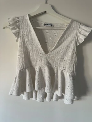 Vit volangblus med spetsdetaljer - Supersöt vit blus, v-ringning och volangkant nedtill. 😍 (Är storlek XXS men passar som S-XS)