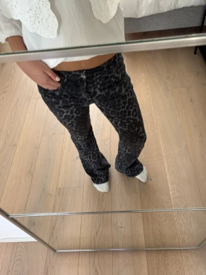 Svarta leopardmönstrade jeans - Säljer ett par as coola, svarta jeans med grått leopardmönster och utsvängda ben från calzedonia. Jeansen har låg midja. Perfekta för dig som vill sticka ut med ett coolt mönster och trendig passform. Priset kan diskuteras!