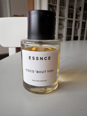 ESSNCE Coco 'Bout You parfym - Parfymflaska från ESSNCE med doften Coco 'Bout You. Flaskan är rund och genomskinlig med svart cylinderformat lock och vit etikett. Innehållet är ljusgult och flaskan är tillverkad i glas med plastlock. Använd några gånger, se bild. 