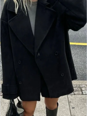 Svart kappa - Stilren svart kappa med dubbelknäppning och breda slag. Oversized passform. Aldrig kommit till användning, så helt oanvänd💌