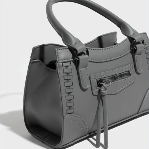 Grå handväska från Gina - Grå väska från Gina, helt slutsåld. Fint skick då den knappt är använd, nypris 400! 