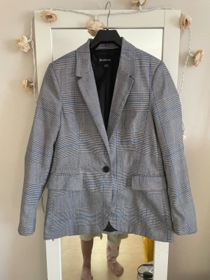 Stradivarius grå kavaj, storlek XS - Stilren grå kavaj med svartvitt rutmönster frå. Stradivarius grå kavaj, storlek XS Klassisk modell med en knapp framtill, två fickor och smal krage. Perfekt oversized fit och helfodrad insida. Materialet är mjukt och känns bekvämt mot huden.