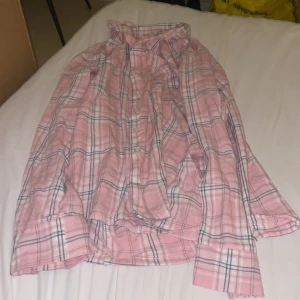 Rosa rutig pyjamas set - Säljer en rosa rutig pyjamas skjorta från 157 i storlek M. Tillhörande byxor .. Mönstret är i rosa, vitt och mörkblått, vilket ger en fräsch och avslappnad look. Perfekt att bära öppen över t-shirt eller knäppt.Nyskick på båda.