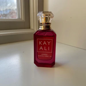 Kayali Lovefest Burning Cherry 48 - Kayali Lovefest Burning Cherry 48 är en parfym i en lyxig, mörkröd glasflaska med guld- och kristalliknande kork. Flaskan har en elegant, kantig form och rymmer en doft med inslag av körsbär. Perfekt för dig som gillar unika och trendiga parfymer.