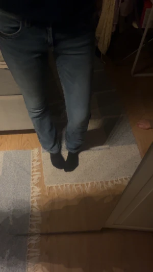 Blå bootcut jeans från Gina Tricot - Snygga blå jeans från Gina Tricot i storlek 170. Modellen har klassisk femficksdesign, normal passform och bootcut-ben som ger en schysst siluett. Jeansen är tillverkade i jeansmaterial med dragkedja och knapp framtill.