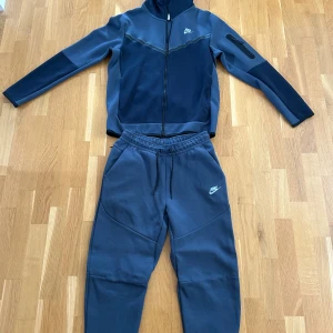 Nike blå mjukisbyxor med snörning - Säljer denna Nike dress som är helt ny. Dressen är inte använd och just därför den säljs till ett bra pris.