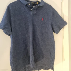 Ralph Lauren pike - Säljer en klassisk pikétröja från Ralph Lauren med korta ärmar. Perfekt för en stilren och avslappnad look.            