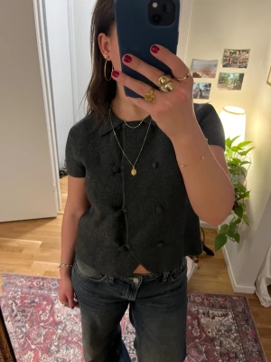 Mörkgrå stickad kofta från Zara - Säljer en mörkgrå stickad kofta från Zara med korta ärmar och krage. 