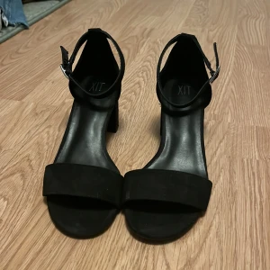 Svarta klackar från XIT - Ett par svarta sandaler från XIT med breda remmar över tårna och går att spänna runt ankeln. Klacken är 6.5cm hög & ca 5.5cm bred. Endast använda en gång och de kommer tyvärr inte till användning🩷Materialet är lite mockalikt och har några få skråmor som inte märks allt för mycket🩷Storlek 37