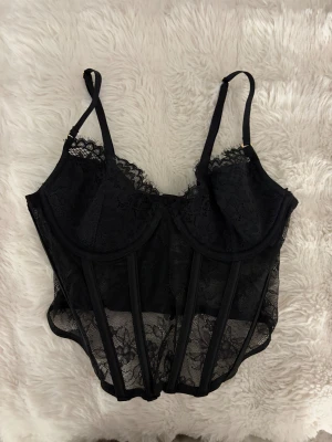 Spets korsett topp  - Säljer denna korsett spets topp från H&M. Aldrig använt så bra skick. Storlek 75A, skulle säga xs-S 