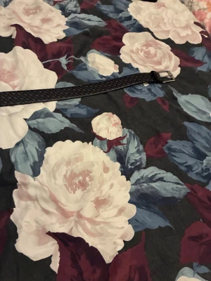 Svart bälte med rutmönster( Hugoboss) - Snyggt hugoboss svart bälte med diskret rutmönster och silverfärgat spänne. Bältet är gjort i konstläder och har en klassisk, smal form som passar till jeans eller kostymbyxor. Perfekt för dig som vill ha en stilren accessoar med lite extra detalj.