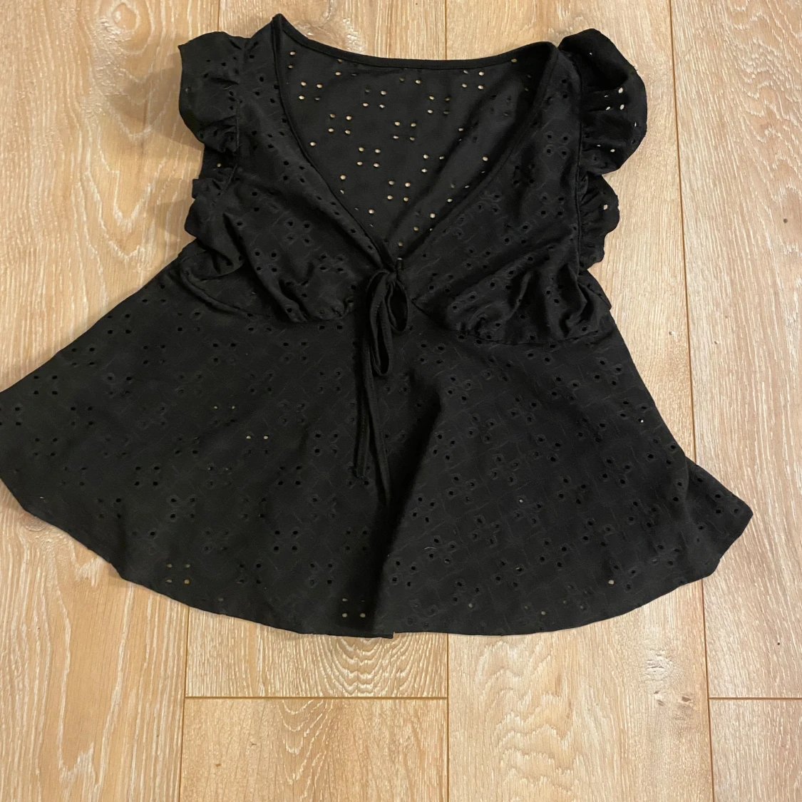 Svart blus med volang och knyt