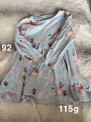 Blå barnklänning med Disney-mönster - Supersöt blå klänning med lång ärm och gulligt Disney-mönster med möss och rosetter i rosa och vitt. Klänningen har en rund halsringning, perfekt för lek och bus.🌸Fint använt skick. Storlek 92