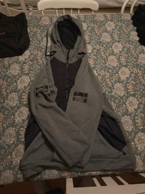 Sailracing jacka/hoddie  - Tja,   Håller på och rensar min garderob. Denna jacka/hoddie kommer inte mer till användning och därav försöker jag sälja den billigt. Jackan/Tröjan är använd men otroligt bra skick. Storlek M - Sitter bra i storleken. Sail racing märkena vid armarna lyser även när det är mörkt så att du syns bra om du är ute när det är mörkt. MVH Hugo, vid fler frågor/bilder vänligen hör av dig. Pri