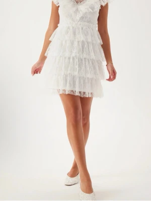 Vit studentklänning från Bubbleroom - Supersöt vit kortklänning från Bubbleroom med flera lager volanger och spetsdetaljer. Klänningen har v-ringning, knappar i ryggen och är ärmlös med romantiska spetskanter. Perfekt för studenten och sommarens alla tillfällen! Helt oanvänd då jag valde en annan klänning i sista sekund