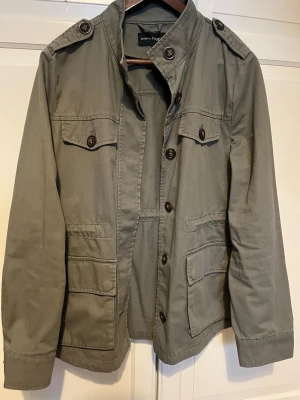 Grön utilityjacka  - Snygg grön overshirt/field jacket från KappAhl i storlek M. Perfekt som lager-på-lager-plagg under vår och höst, eller som lätt jacka. Klassisk modell som funkar både till vardags och mer uppklätt.  Färg: grön (olivgrön) Storlek: M Passform: normal Skick: bra/använt skick (inga större anmärkningar)  Passar dig som gillar stilrent, minimalistiskt eller workwear-inspirerat. Skicka gärna meddelande vid frågor eller om du vill ha mått 🌿