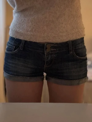 Mörkblå lågmidjade jeansshorts  - Säljer ett par blå lågmidjade jeansshorts i storlek L, midjemått:42cm! 