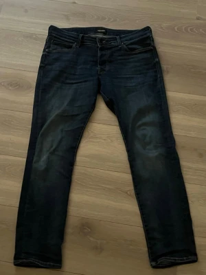 Mörkblå skinny jeans från Jack & Jones - Säljer ett par mörkblå skinny jeans från Jack & Jones, modell Slim Glenn. Jeansen har klassisk femficksdesign, smal passform. Materialet är stretchigt jeans för extra komfort och de har normal midja med dragkedjegylf. Bara här av er vid frågor.