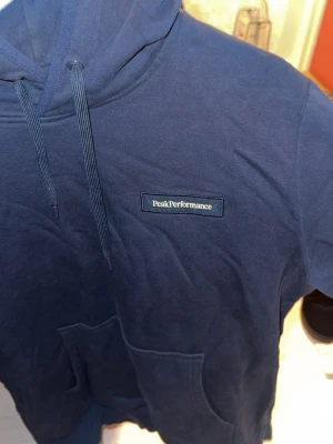 Marinblå peak performance hoodie - En peak hoodie som nästan är oanvänd. Enbart tvättad några enstaka gånger. 350 kr plus frakt. Storlek M