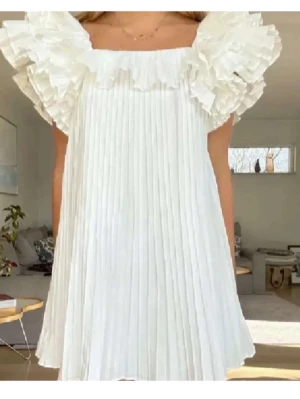 Vit plisserad klänning från Zara - Superfin eftertraktad vit kortklänning från Zara med plisserat tyg och stora volangärmar. Klänningen är perfekt till studenten också❤️❤️❤️