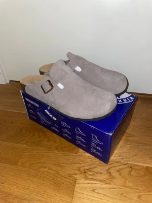 Birkenstock Boston - Ett par helt nya Bireknstock Boston i grå mocka. Prislappen fortfarande kvar. Sitter som 43 men kan även passa 42. Skriv gärna om du har några frågor! Priset kan diskuteras.