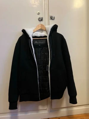  Moose Knuckles bunny  - Säljer en svart teddyjacka från Moose Knuckles med vit fluffig päls på insidan och huva. Jackan har dragkedja, två fickor fram och en snygg metallogo på ärmen. Orderbekräftelse finns! Perfekt för kalla dagar när du vill vara både varm och stilren. Håller värmer mkt bra o är väldigt skön. Tveka inte på o höra av er! PRIS GÅR ATT DISKUTERAS!!!