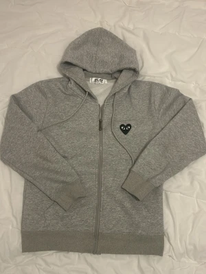 Comme des Garçons - zip hoodie - En grå CDG zip up hoodie i storlek S, be gärna om måtten så att tröjan passar innan jag skickar! Denna är extremt fet och helt ny! Jag säljer denna till det billiga priset av 699kr