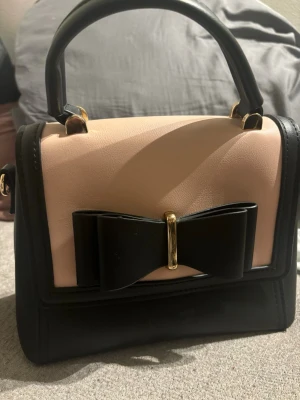 Svart och rosa väska   - Svart och rosa krisbella väska. Ganska ny med inga skador. Pris kan diskuteras 