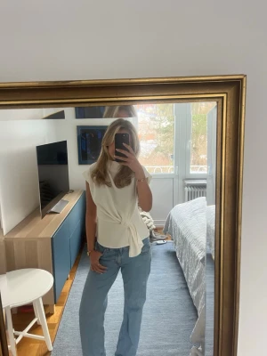 Vit blus med knyt i midjan - Säljer en vit blus med knyt i midjan som är perfekt att matcha med jeans eller kjol. Köpt på zara för ca 3 år sedan!