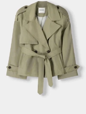 Grön trenchcoat från Bershka - Säljer en snygg trenchcoat från Bershka med bred krage, knytskärp i midjan och dubbla knappar framtill. Använd två gånger så nyskick! Perfekt för vår och höst.