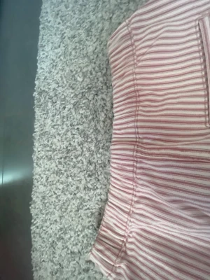 Randig kortkjol från Tommy Hilfiger - Säljer en söt kortkjol från Tommy Hilfiger med smala röda och vita ränder. Kjolen har två framfickor och en bakficka, samt en klassisk rak passform. Perfekt för sommarens alla tillfällen och enkel att matcha med en t-shirt eller linne. Pris kan diskuteras 