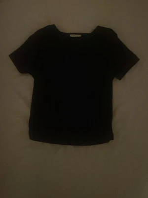 Svart basic t-shirt med kort ärm  - En stilren svart t-shirt med klassisk rund hals och korta ärmar. Perfekt för dig som gillar enkla och tidlösa plagg. T-shirten har en rak passform och är gjord i mjukt material som känns skönt mot huden.