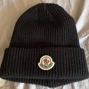 Moncler mössa - Säljer denna moncler mössa pga att jag har slutat använda den behöver pengar, köpte den för 500 och nu för 300 hör av för frågor eller funderingar