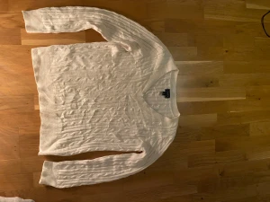 Vit kabelstickad tröja med v-ringning av Raulph lauren(chaps) - Säljer en vit kabelstickad tröja från Raulph lauren(chaps) Tröjan är otroligt skön och har najs passform. Modellen i bilden är 182 och väger ca 73 kilo. Tröjan är i XL men sitter som L👌priset är inte stucket i kistan utan kan diskuteras!