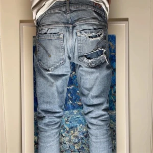 Ljusa slitna jeans från dondup - Säljer ett par ljusblå jeans från dondup med flera slitningar och hål både fram och bak för en riktigt edgy look. Modellen har raka ben och klassisk femficksdesign med knappgylf. Perfekt för dig som gillar streetstyle och vill sticka ut. Skick 9/10 priset ej hugget i sten🤩 hör gärna av er vid minsta lilla fundering 🤔😇