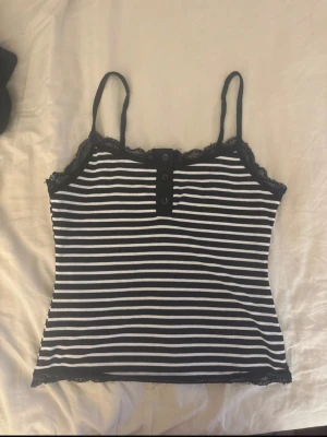Randig svartvit linnetopp med spets - Randigt linne i lite y2k stil. Storlek xs-S och köpt på Shein❤️
