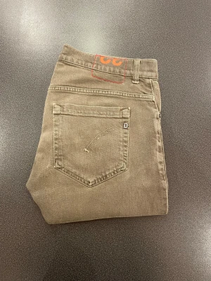 Dondup Jeans George Grå  - Ett riktigt fint par Dondup Jeans i grå färg. Storleken är jag rätt så osäker på för lappen blivit avklippt men passar dig som normalt har W30 L32. Jag är 178 och väger 67kg och dem passar mig bra (kolla bild 2). Bra skick och det finns inga större defekter men dock är ena fickan lite repor på (se bild 6) och fickan på insidan är ihopsydd och reparerad (bild 7). Hör av dig vid frågor! 