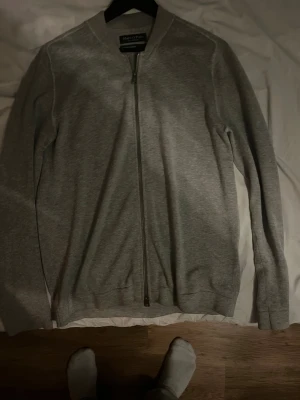 Grå kofta från Marc O'Polo med dragkedja - Snygg grå kofta från Marc O'Polo i mjuk bomull och kashmirmix. Modellen har lång ärm, rund hals och hel dragkedja framtill. Perfekt för dig som gillar stilrena och bekväma plagg med clean look. Hör av er vid minsta fråga!