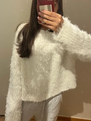 Fluffig tröja från Wera - Supermjuk och fluffig vit stickad tröja från Wera. Tröjan har lång ärm, rund hals och oversized passform. 