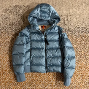 Parajumpers Women Downjacket Mariah-W - Puoli talvea hellästi käytetty Parajumpersin Mariah untuvatakki, joka on oleskellut kaapissa suurimmaksi ajaksi.  Takissa ei ole mitään isoja tahroja jotka näkyisivät tai vaikuttaisivat ulkonäköön. Ihan tavallista kulumaa.  Koko: M Väri: Vaaleansininen / Turkoosi Naisten mallia