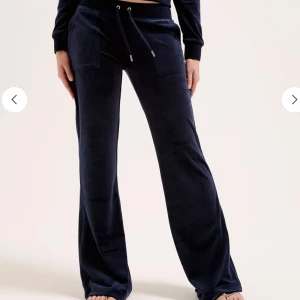 Mörkblå Juicy couture byxor - Snygga mörkblå juicy couture byxor med mjuk sammet, resår och snörning i midjan. Det är stora fickor fram och bak med knappdetaljer. Perfekta för chill dagar. 
