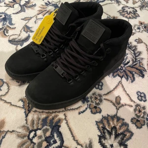 Svarta Timberland kängor herr 43 - Timberland kängor i helsvart mocka med Aerocore Energy System. Perfekt för dig som gillar stilrena och funktionella boots men ändå klarar vintern! Skick: 10/10 (helt nya utan kartong, aldrig använda), Storlek: 43. Tveka inte att höra av er vid minsta lilla fundering eller intresse!