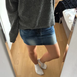 Mörkblå jeanskjol med fickor - Snygg mörkblå jeanskjol med slitna detaljer och tre silverfärgade knappar framtill. Kjolen har klassiska fickor både fram och bak, aldri använt!!❣️❣️