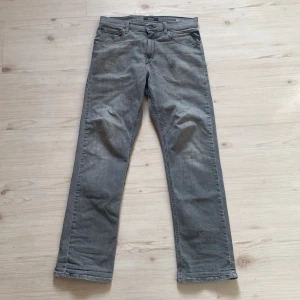 Grå Replay jeans straight fit - Snygga grå jeans från Replay i klassisk straight fit. Jeansen har fem fickor, bälteshällor och Replay-logga på bakfickan samt läderpatch bak. Tillverkade i mjukt jeanstyg som är skönt att bära hela dagen.