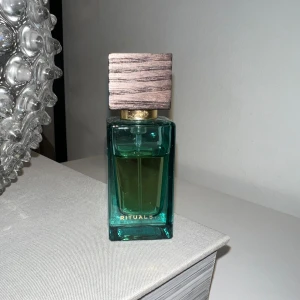 Rituals parfym med trälock - Stilren parfym från Rituals med snygg trädetalj på locket. Perfekt för dig som vill ha en modern och fräsch accessoar på hyllan. Volym och ingredienser syns ej på bilden.