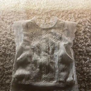 Vit spetsblus från Only - Supersöt vit blus från Only med blommigt spetsmönster och högt halsringning. Har använt knappast 2 gånger