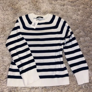 Randig stickad tröja från Bik Bok  - Snygg stickad tröja från Bik Bok i storlek XS. Tröjan är vit med marinblå ränder. Aldrig använd! 