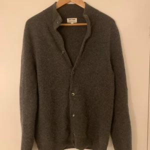 Mörkgrå kashmirkofta från Soft Goat - Mysig mörkgrå kofta från Soft Goat i 100% kashmir. Klassisk rak modell med knappar framtill och långa ärmar. Perfekt för lager-på-lager och riktigt skön mot huden. Enkel och stilren design som funkar till allt. (Passar även M)