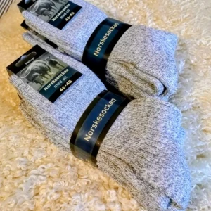 Ullsocker /Norskesockan Med 50 % Ull  - Stl 34/36, 37/39 och 46/48 3 par/ 130Kr,  Norskesockan är tillverkade i en mjuk ullblandning som håller fötter varma och behagliga alla dagar om året. Dessa strumpor har ribbstickning som ger en flexibel mer anpassad passform och en insida av mjuk frotté vilket ger extra komfort. Även sulan på strumporna har en lite extra mjuk frottédämpning vilket ger dig ett mjukt behagligt nedtramp när du går. Dessa ullstrumpor passar även perfekt som arbetsstrumpor. Strumporna påminner mycket om raggsockor